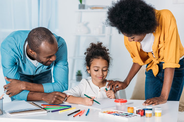 Wall Mural - african american parents helping daughter drawing at home