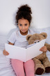 © LIGHTFIELD STUDIOS - adorable african american kid holding book and looking at camera at home