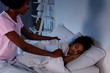 © LIGHTFIELD STUDIOS - african american mother covering sleeping daughter with blanket