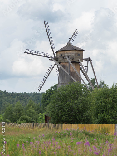 Plakat Stary drewniany wiatraczek w zieleni polu w lecie