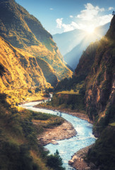Wall Mural - Colorful landscape with high Himalayan mountains, beautiful curving river, green forest, blue sky with clouds and yellow sunlight at sunset in autumn in Nepal. Mountain valley. Travel in Himalayas