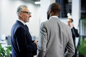 Wall Mural - selective focus of multicultural businessmen having conversation in office