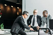 © LIGHTFIELD STUDIOS - Businessmen discussing in office