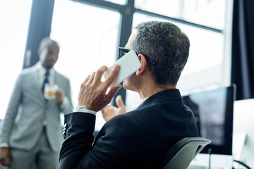 Wall Mural - selective focus of businessman talking on smartphone in office