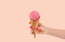 Hand Holding Strawberry Ice Cream Cone On White Background
