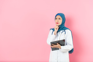 Wall Mural - attractive woman muslim doctor carrying clipboard