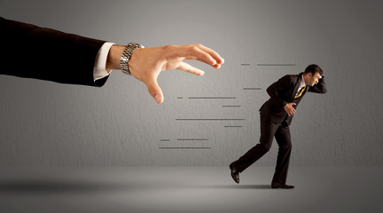 Wall Mural - Businessman running away from a huge hand