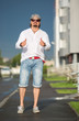 © vasilievae - A man is walking in the courtyard on a sunny day. Lifestyle, movement, style, fashion.