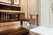Glass door design in the sauna and shower cabin with metal door hinge in the interior