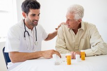 Nurse Giving Medicine To Senior Man