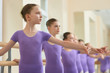 © DenisProduction.com - Close up young ballerinas practicing ballet. Group of beautiful ballet girls doing ballet exercises at ballet barre in studio.