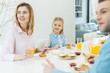 © LIGHTFIELD STUDIOS - happy family looking away while having breakfast together at home