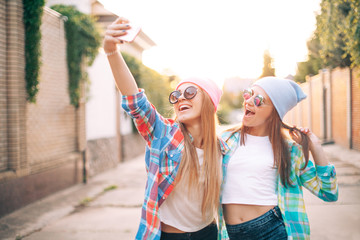 Wall Mural - Lovely young females are taking selfie in the city.