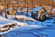 © Maryna - Rural landscape with old abandoned watermill in woods. Beautiful winter view with frozen river in front of old wooden water mill and barn in a snowy forest during sunset.