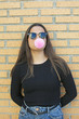 teenager with glasses and  bubble gum