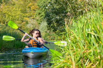 Wall Mural - Family kayaking, mother and child paddling in kayak on river canoe tour having fun, active autumn weekend and vacation, fitness concept
