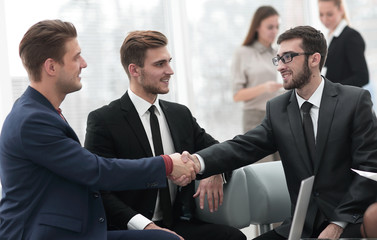 Poster - Partners concluding deal and shaking hands in the presence of team members