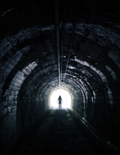 Silhouette Standing In Dark Tunnel