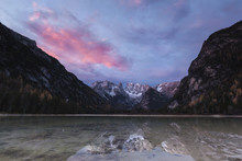 Scenic View Of Lake By Mountains Against Sky During Sunrise