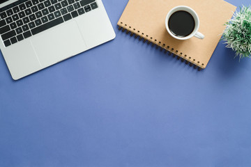 Minimal work space - Creative flat lay photo of workspace desk. Top view office desk with laptop, notebooks and coffee cup on blue color background. Top view with copy space, flat lay photography.