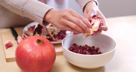 Poster - Putting Fresh red pomegranate into bowl