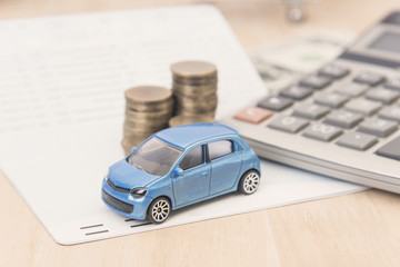 car with calculator and money on wood table. auto loan concept.