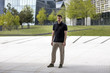 © Nektarstock - Portrait of a man standing in front of modern buildings. Full body shot.