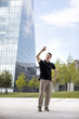 © Nektarstock - Man Making Hand Gestures in Front of Glass Building