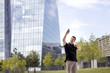 © Nektarstock - Man Making Hand Gestures in Front of Glass Building