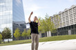 © Nektarstock - Man Making Hand Gestures in Front of Glass Building