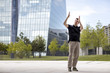 © Nektarstock - Man Making Hand Gestures in Front of Glass Building