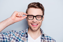 Portrait  Of Smart, Clever, Happy, Positive Guy Holding Eyelet Of Glasses On Face Looking At Camera Over Grey Background