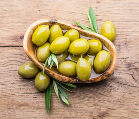 Wall Mural - Whole table olives in the wooden bowl on the table.