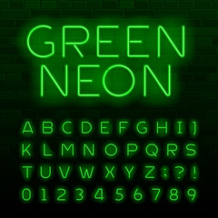 Fototapete - Green neon lamp alphabet font. Neon color shiny letters, numbers and symbols. Brick wall background. Stock vector typeface for any typography design.