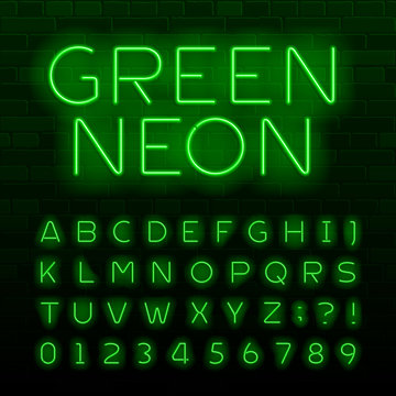 Green neon lamp alphabet font. Neon color shiny letters, numbers and symbols. Brick wall background. Stock vector typeface for any typography design.