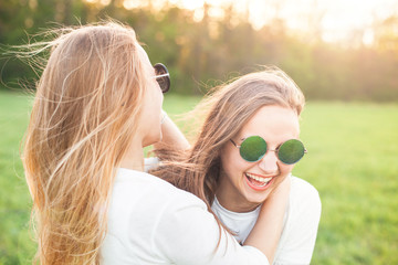 Wall Mural - Two women in sunglasses and white shirts are having fun