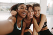 © Jacob Lund - Smiling women friends taking selfie in fitness studio