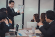 © 88studio - businessman present financial plan report to co worker team. man leader discuss sales data with investor colleagues. finance investment business meeting