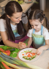 happy family mother and child daughter are preparing healthy food, they improvise together in the ki