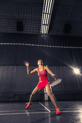 Wall Mural - Young woman playing badminton at gym