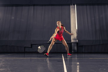 Wall Mural - Young woman playing badminton at gym