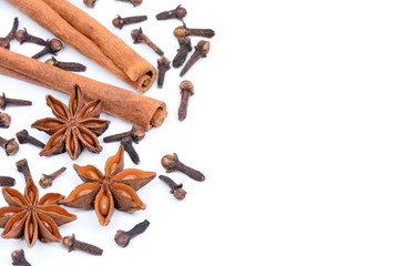 Wall Mural - Cinnamon sticks with star anise and cloves on white background