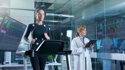 Wall Mural - woman athlete runs on a treadmill with electrodes attached to her body while scientist holding table