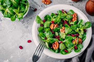 Healthy green Lamb’s lettuce salad with walnuts and pomegranate seeds