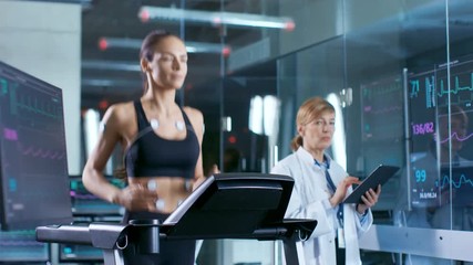 Wall Mural - beautiful woman athlete runs on a treadmill with electrodes attached to her body, female physician u