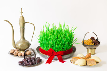 Novruz national Azerbaijan holiday spring new year celebration concept, wheat grass semeni pear shape glass of tea,  traditional pakhlava shekerbura 