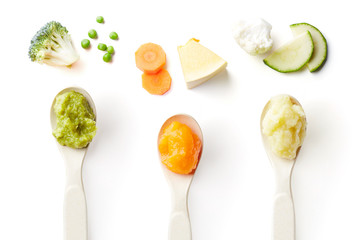 Three baby spoons of baby puree isolated on white from above