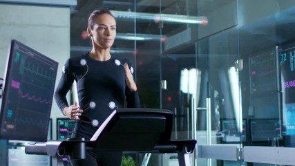 Wall Mural - in scientific sports laboratory beautiful woman athlete runs on a treadmill with electrodes attached