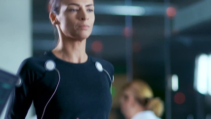 Wall Mural - in scientific sports laboratory beautiful woman athlete runs on a treadmill with electrodes attached
