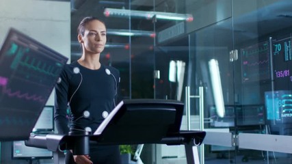 Wall Mural - in scientific sports laboratory beautiful woman athlete walks on a treadmill with electrodes attache